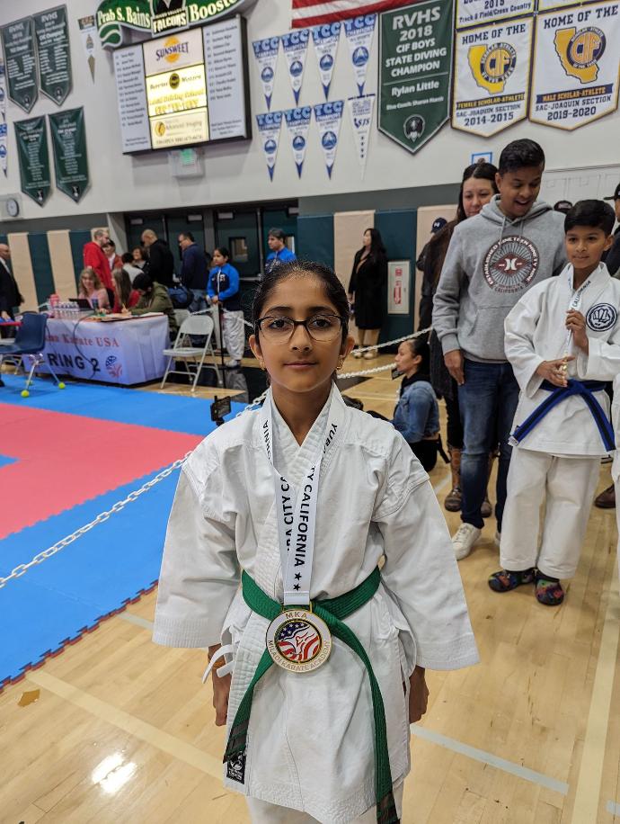 Pranshi wearing a gold medal from novice girls kata