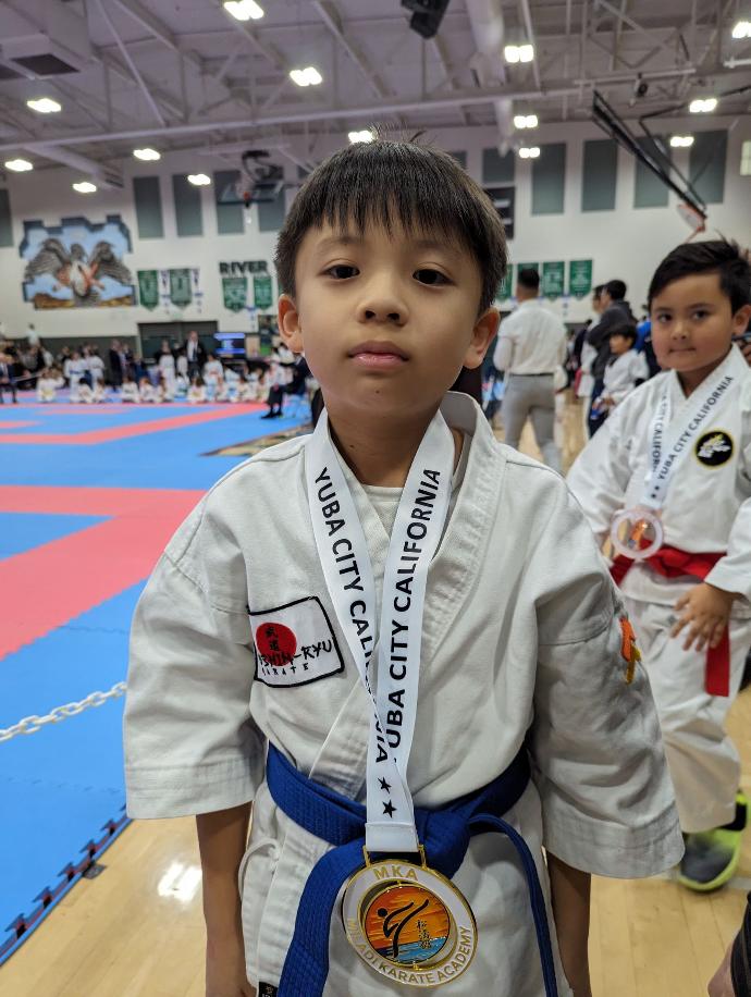 Kevin wearing a gold medal from novice boys kata